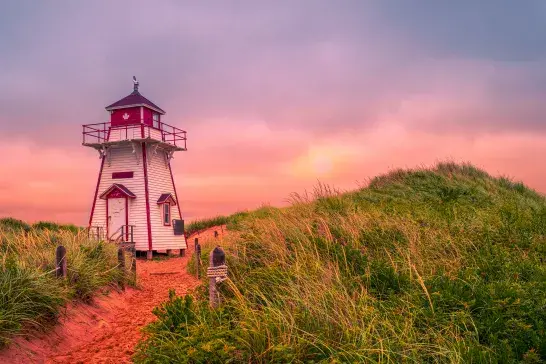 A lighthouse at sunset on a PEI beach
