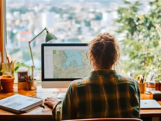 A woman sitting in front of a screen with travel details on it